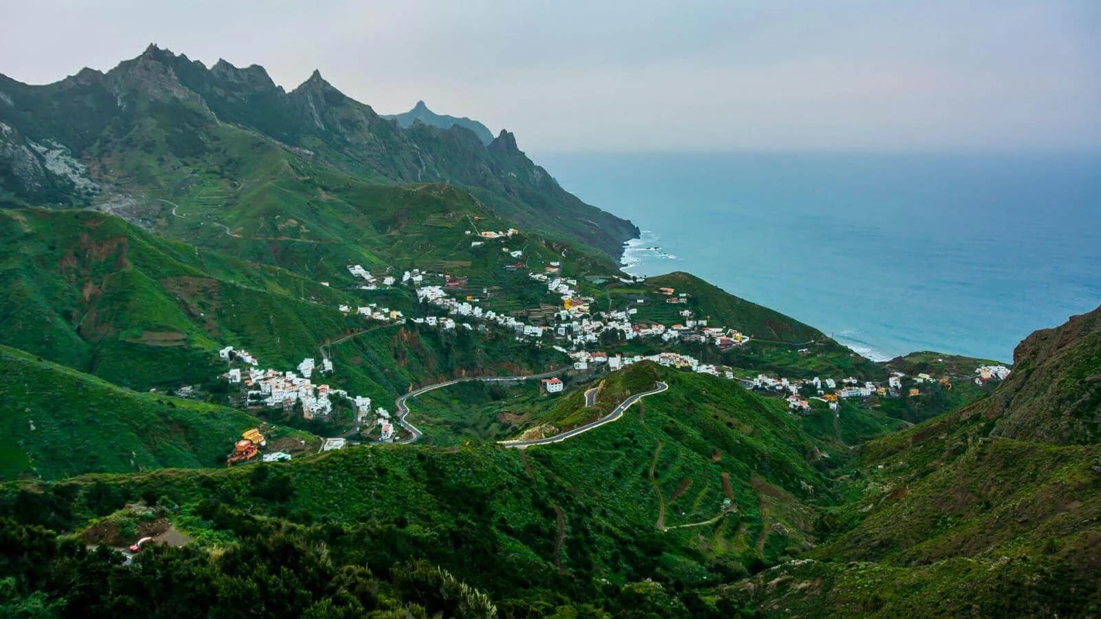 Vista aérea del pueblo de Taganana, casas blancas aferradas a la ladera de la montaña sobre el océano Atlántico