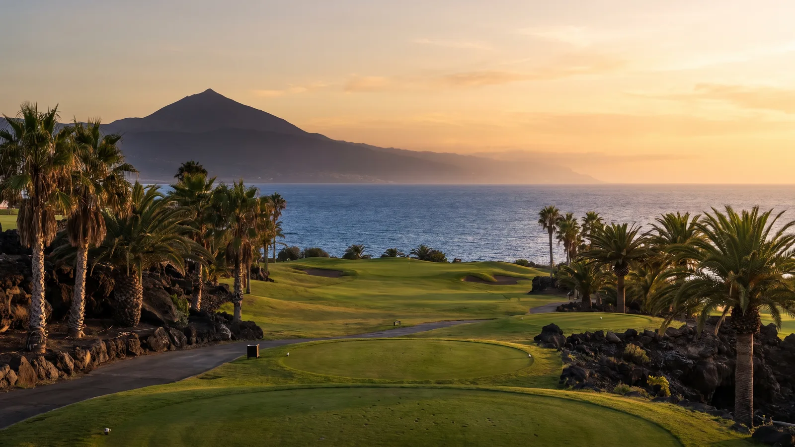 Green of a golf course in Tenerife with the ocean and Mount Teide in the background