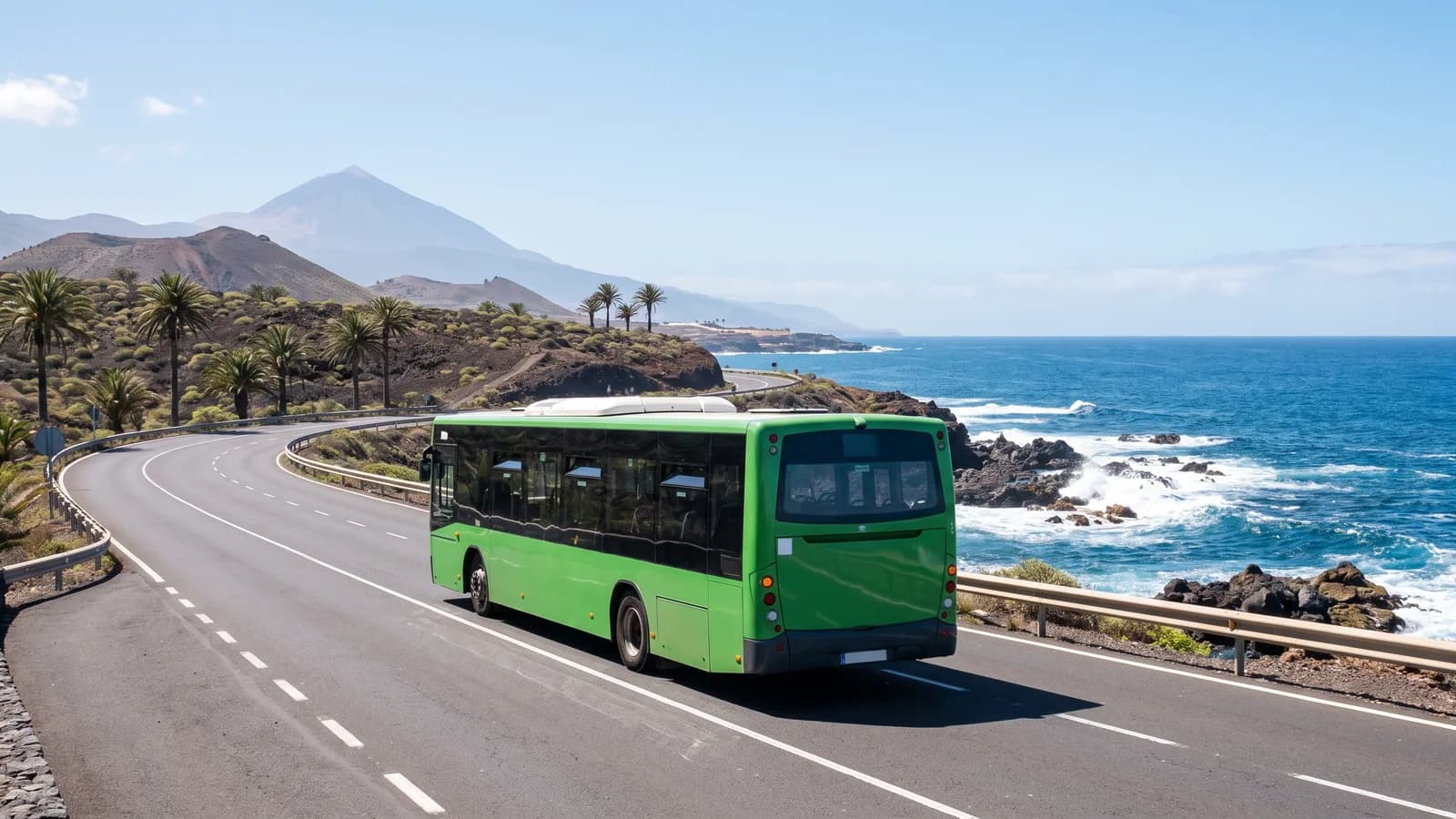 Una guagua verde en una carretera costera de Tenerife con el Teide al fondo: moverse por la isla sin coche